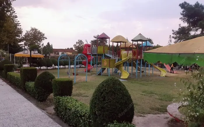 پارک بازی بچه ها و فضای سبز پوشیده از درختان کاج در شهرک خزرشهر 63526312314631