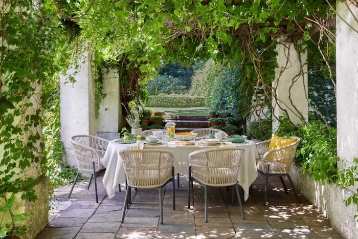 چیدمان میز و صندلی در پاسیو و تزیین آن با گیاهان سبز